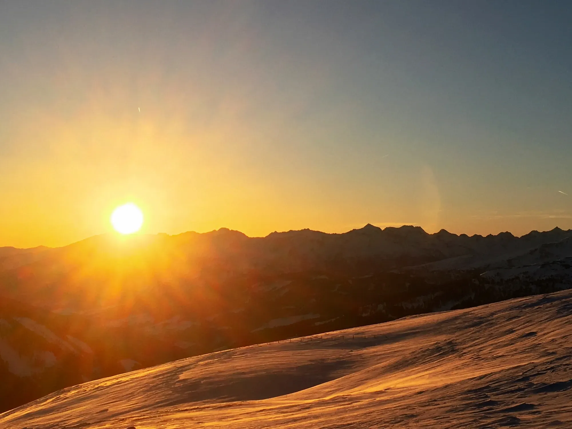 Sonnenuntergang über verschneiten Bergen